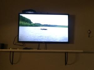 a flat screen tv on a shelf in a room at Deptos Punta Nevada in San Carlos de Bariloche