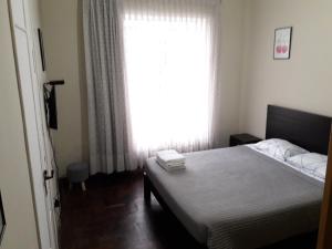 1 dormitorio con cama y ventana grande en Cozy and Comfortable Home in MIRAFLORES, en Lima