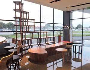 a restaurant with wooden tables and chairs and large windows at Hotel N°5 in Kota Kinabalu