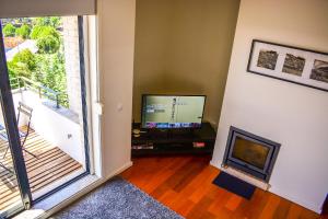 un salon avec une télévision et une cheminée dans l'établissement Porto Cozy House, à Porto