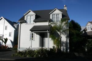 uma casa branca com um telhado preto em Settler's Cottage - Russell Cottages Collection em Russell