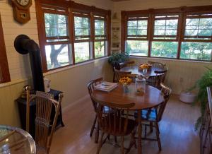 a dining room with a table and chairs and windows at Fairmount Bed & Breakfast in Basswood