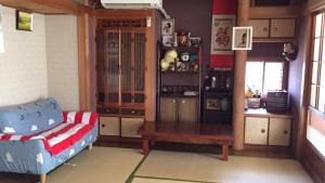 Ibusiki Chinese Minshuku في إيبوسوكي: غرفة معيشة مع أريكة وكرسي