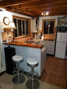 a kitchen with two bar stools and a counter top at Bundera Lodge in Vacy