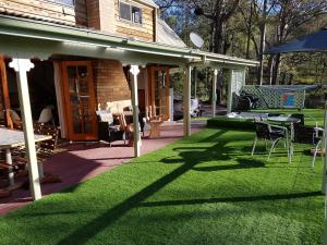 VacyBundera Lodge的庭院设有草坪,配有桌椅