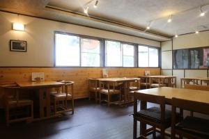 a restaurant with wooden tables and chairs and windows at Ringoya in Hakuba