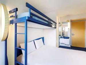 een blauw stapelbed in een kamer met een bed bij ibis Budget Pouilly-en-Auxois in Pouilly-en-Auxois