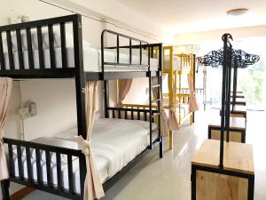 a room with two bunk beds and a table at Daizy House in Chiang Mai