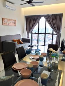 ein Wohnzimmer mit einem Tisch, Stühlen und einem Sofa in der Unterkunft Splendid Suite 2 Bedroom @ Sunway & PJ in Petaling Jaya