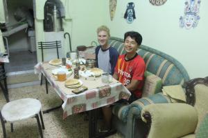 Due uomini seduti a un tavolo in un soggiorno di Bunksurfing Hostel a Bethlehem Altre 12 foto