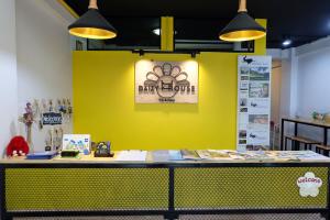 a yellow wall with a table with a sign on it at Daizy House in Chiang Mai