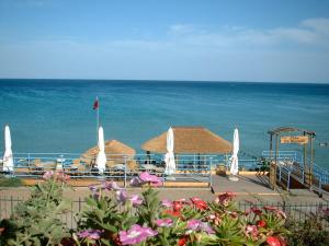 a beach with umbrellas and chairs and the ocean at Residence Arenella in Arenella