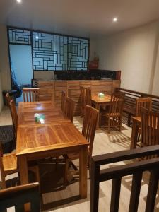 库塔Praba Guesthouse的用餐室配有木桌和木椅