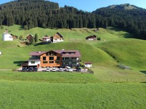 una casa en una colina en un campo verde en KWT Lodge, en Mittelberg