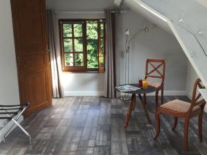 een kamer met een tafel en stoelen en een raam bij Le moulin régnelot - Chambre d'hôtes in Verdelot