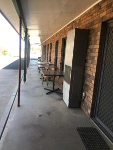 a bench in front of a brick building at Stockman Motor Inn in Narromine