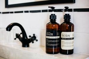 two bottles of hair products sitting on a bathroom sink at The51Hometel in Chiang Mai