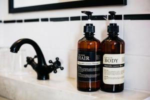 two bottles of hair products sitting on a bathroom sink at The51Hometel in Chiang Mai +90 photos