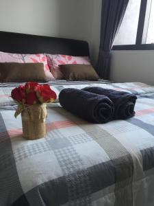 ein Bett mit Handtüchern und einem Korb mit Blumen darauf in der Unterkunft Splendid Suite 2 Bedroom @ Sunway & PJ in Petaling Jaya