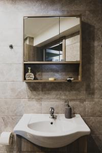 a bathroom with a sink and a mirror at Lenti Street House in Kallirákhi +30 photos
