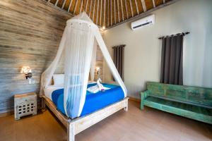 een slaapkamer met een bed met een schommel bij Song Lambung Beach Huts in Nusa Lembongan