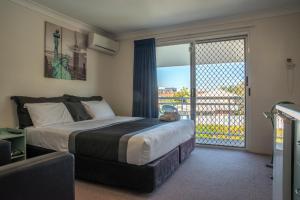 a bedroom with a bed and a window at Chermside Court Motel in Brisbane