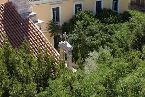 雅典的住宿－雅典藝術家酒店，屋旁灌木丛中的十字架