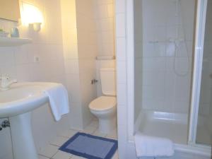 a bathroom with a toilet and a sink and a shower at Hotel Villa Strandrose in Ahlbeck