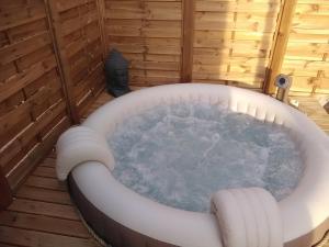 a jacuzzi tub in the middle of a room at TINY HOUSE & SPA climatisée in Faycelles