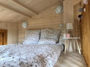 una camera con letto e parete in legno di TINY HOUSE & SPA a Faycelles
