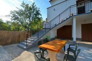 une table et des chaises en bois sur une terrasse avec un escalier dans l'établissement Apartment Nada with Private Pool, à Buzet