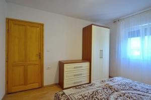 een slaapkamer met een bed, een dressoir en een deur bij Apartment Nada with Private Pool in Buzet