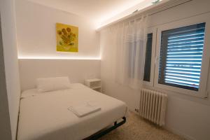 a bedroom with a bed and a window at Hostal Marina Cadaqués in Cadaqués