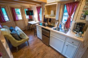 une cuisine avec un évier et un canapé dans une caravane dans l'établissement Mount Hood Village Scarlett Tiny House 3, à Welches