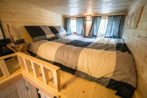 ein Schlafzimmer mit einem Bett in einer Holzhütte in der Unterkunft Mount Hood Village Atticus Tiny House 8 in Welches