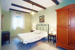 a bedroom with a bed and a dresser and a window at La Bodeguita in Benaocaz