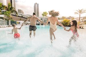 um grupo de pessoas brincando na água em uma piscina em Hard Rock Hotel Tenerife em Adeje
