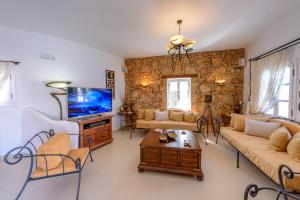 a living room with a couch and a tv at Chora Resort Hotel & Spa in Chora Folegandros