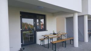 a patio with two tables and benches and a window at SEA & LAKE in Jarosławiec
