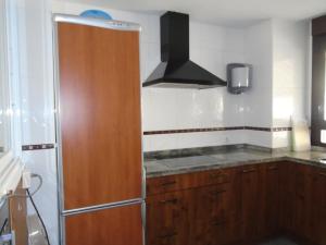 una cucina con armadio in legno e frigorifero di Apartamento Victoria a Cirueña Altre 7 foto
