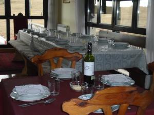 a dining table with a bottle of wine and chairs at Apartamento Victoria in Cirueña