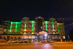 a building with green lights in a city at night at Vila Verde in Chişinău