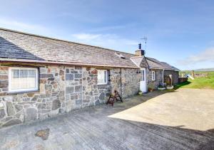 a stone house with a large driveway in front of it at Stabal Madrun in Abersoch