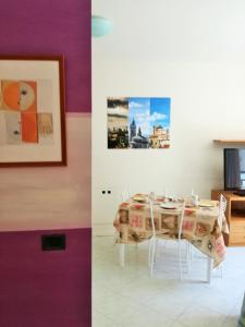 un comedor con una mesa y una pintura en Bergamo City Apartments, en Bérgamo