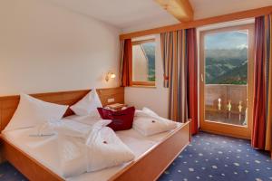 a hotel room with a bed with a large window at Hotel Panorama in Ladis