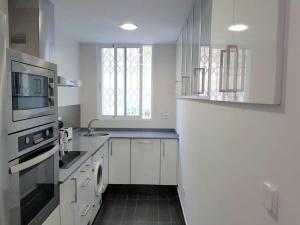 バレンシアにあるFLORIT FLATS - The Jardines del Turia Apartmentの白いキッチン(シンク、電子レンジ付)
