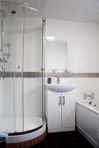 a bathroom with a shower and a sink and a tub at The Mouries Holiday Cottage in Fochabers +6 photos