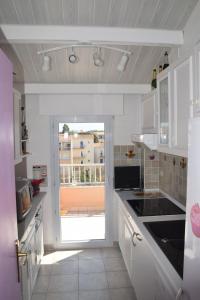a kitchen with a door open to a balcony at le lagon bleu - Fréjus in Fréjus