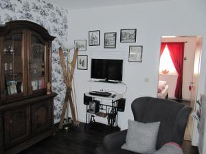 ein Wohnzimmer mit Fernseher und Sessel in der Unterkunft Piepmäker Stübchen in Goslar
