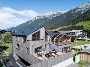 een extern uitzicht op een huis met bergen op de achtergrond bij Ferienhaus zum Stubaier Gletscher - Dorf in Neustift im Stubaital